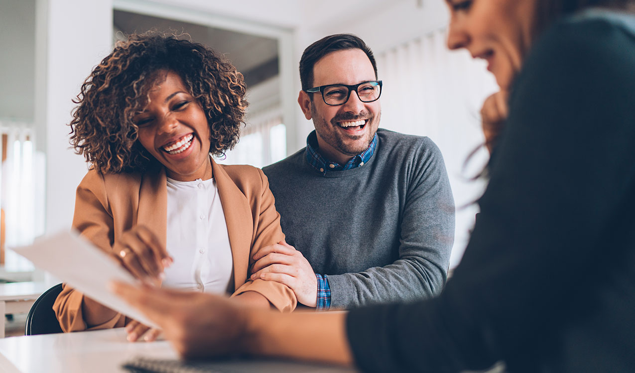 http://Couple%20smiles%20during%20meeting%20with%20financial%20advisor